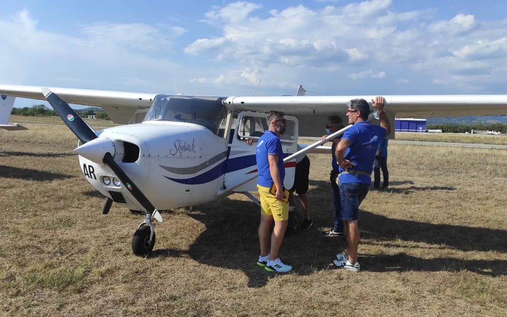 Membri del gruppo accanto a un Cessna all'aeroporto di Boscomantico